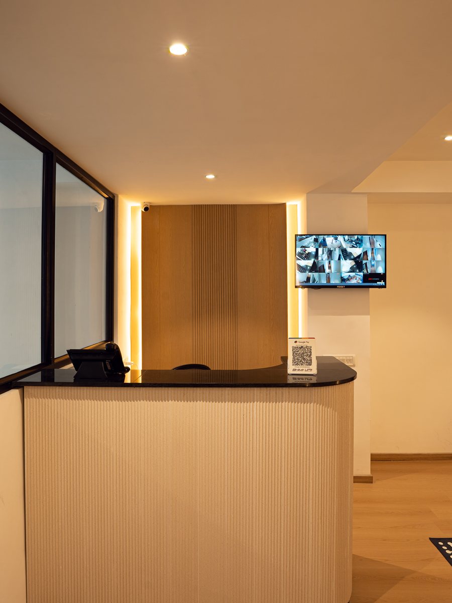 Reception desk at The Roost, Nungambakkam — fluted timber counter and warm backlighting